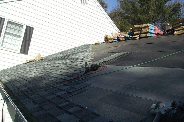 A close up on the new shingle roof mid-installation shows how the shingles are staggered, as well as the way they are nailed down to avoid seams from forming.