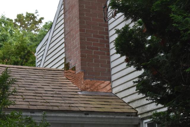 Copper chimney flashing installed after a torn aluminum flashing job failed to protect the home from water damage.