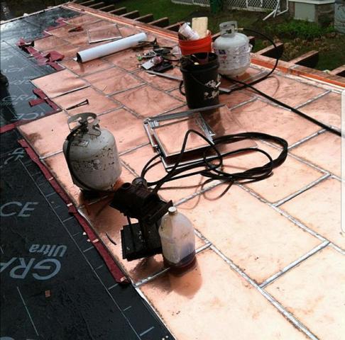 Most of the roof is completed here, and you can see some of the equipment that our crew uses to install the copper panels.