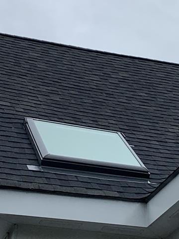 Exterior Roof work surrounding skylight including shingles and flashing.