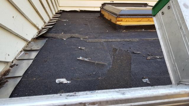 The worn out shingles have been removed, and it is clear that the layers underneath need to be replaced as well.