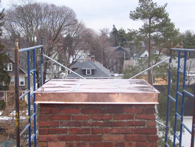 Our crew has finished this project, with the top of the chimney cap being installed. The copper makes the chimney cap look great, and the perfect seal around it along with the ice & water shield underneath will make sure that this chimney will not cause any more headaches for this happy homeowner.