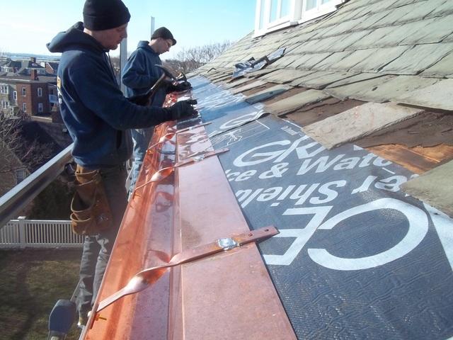 The lower levels of slates have been removed so ice & water shield can be applied, followed by the crew attaching the new copper gutters.