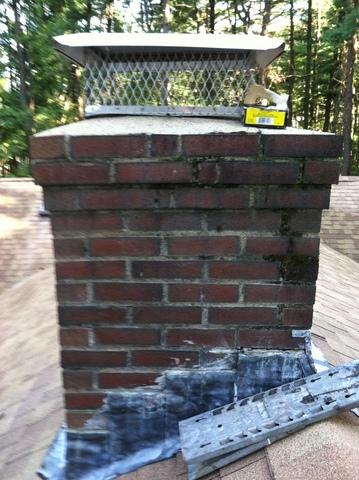 This chimney shows clear signs of damage, as the flashing is worn out and the bricks are cracked and allowing water to leak into the chimney.