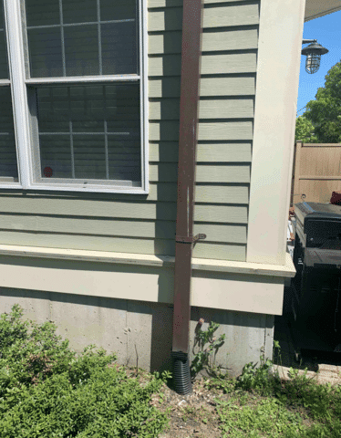 Copper downspout prior to being replaced. Had clogging and significant damage.

