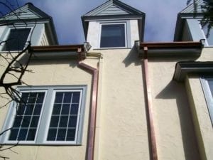 Copper downspouts installed by a roofing contractor in Newton, MA.