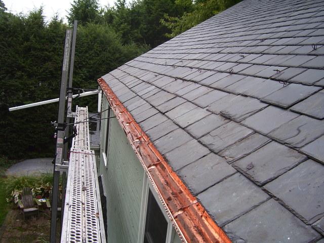 After installing the copper gutters we re-installed the slate shingles onto the roof.