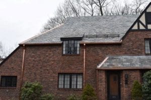 A Newton home with a slate roof and copper gutters and downspouts. We are your local Newton roofing contractor.