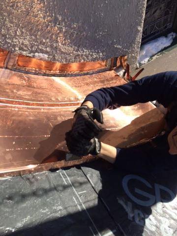 Here we can see one of our expert craftsmen putting the copper panels into place, making sure the curve fits properly against the shape of the roof. Ice & water shield is also applied to make sure water can't leak into the roof anymore.