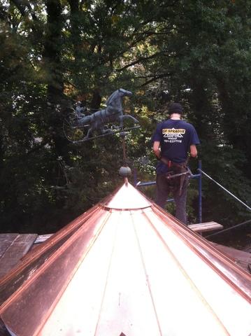 The new copper top has been installed, and one of the crew members who worked on the project can be seen.