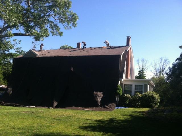The crew tarps off the front of the house, which ensures that they can freely remove the existing roof without any risk of falling debris damaging the house.