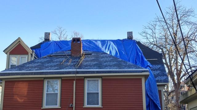 A tarp is set up overhanging the roof, this ensures that any debris falls safely to the ground and does not damage the home.