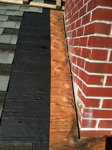 Once the shingles closest to the chimney have removed, it is clear that there is a small gap between the chimney and the plywood, which could allow leaks.