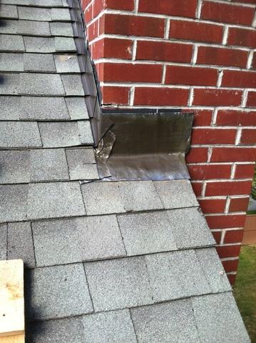 With the ice shield installed, the shingles can be replaced over the top of it, with flashing seen to hold the new underlayments tight against the chimney.
