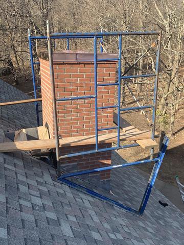 Installing a copper chimney cap onto the chimney