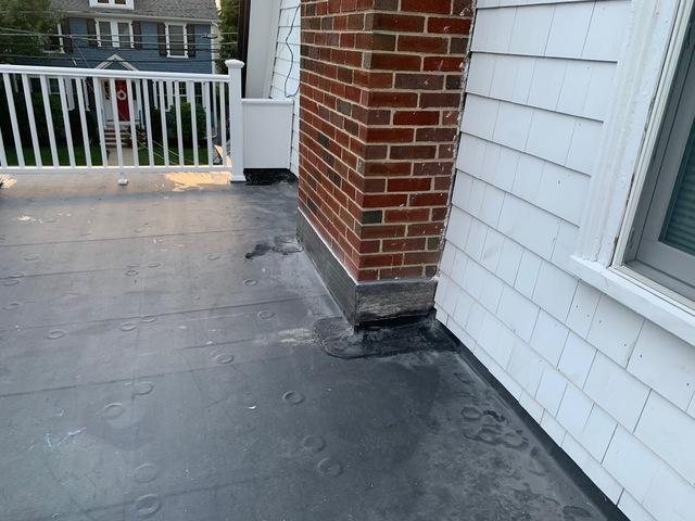 Flat roof adjacent to chimney and home.

