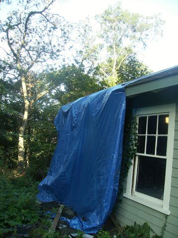 Our crew tarps off the roof to start, that way all of the removed shingles can be slid down the tarp and stay neat at the bottom of the tarp. This ensures that there is not debris all around the garage when the job is done.