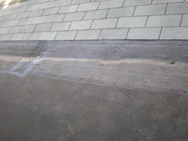 A close up shot shows how the newly repaired section of the roof seamlessly ties into both the existing flat roof and shingle roof, ensuring this roof will be watertight and leak free!
