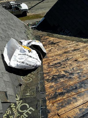 The roof has been stripped down to the wood, and the damage to the roof and the ice & water shield is clearly evident.