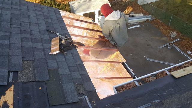 One of our crew members works on installing the copper panels. These will prevent any snow or water from getting into the roof and will help alleviate any damage the customer would have had from ice dams in the future.