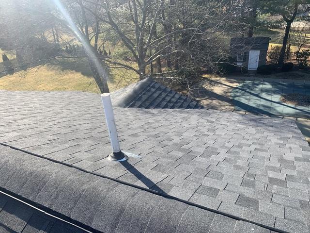 Installed shingle roof with ridge ventilation and soil pipe.