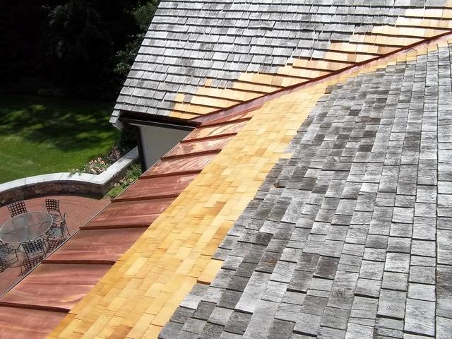 Top down view of copper panel on wood shingle roof.