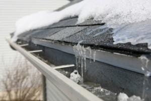 Ice dam on gutters and asphalt shingle roof.