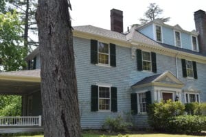 Colonial home with blue cedar clapboard siding and asphalt shingle roof.